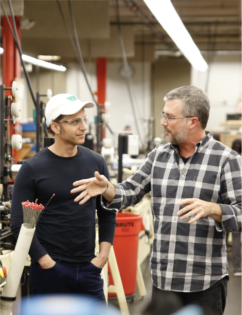 2 People talking in a guitar string factory