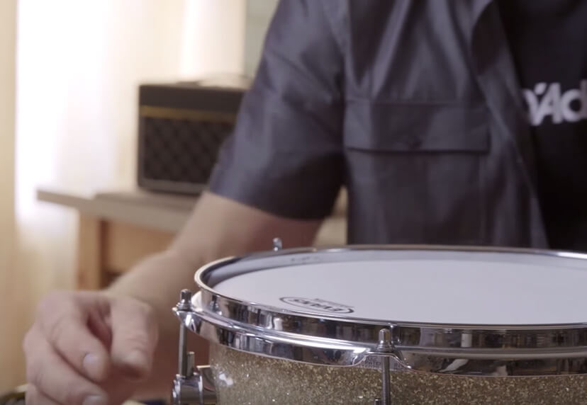 Person tuning a tom drum